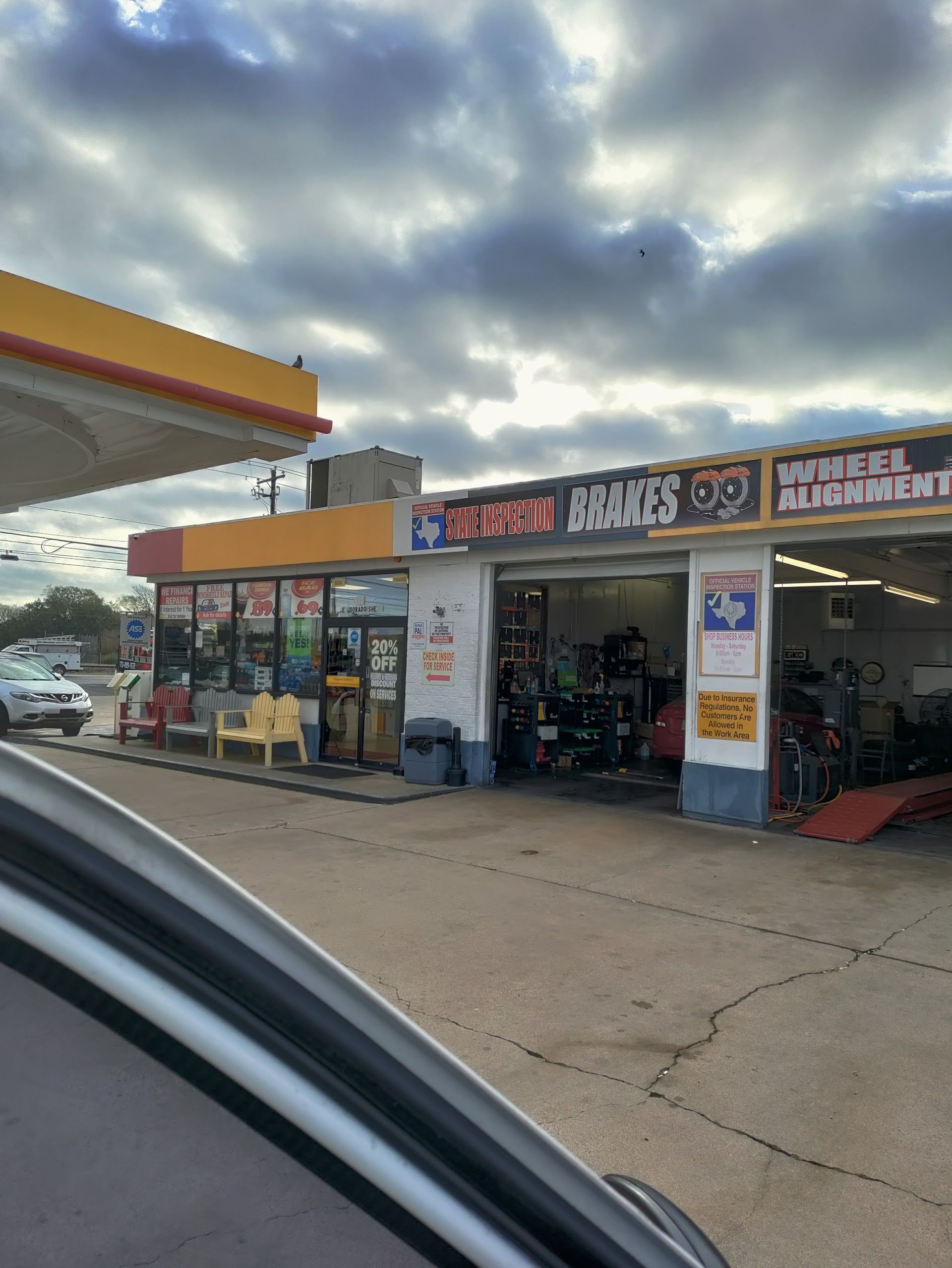 A gas station with a tire repair shop. Cloudy sky. Shell gas pumps to the left. | El Dorado Shell