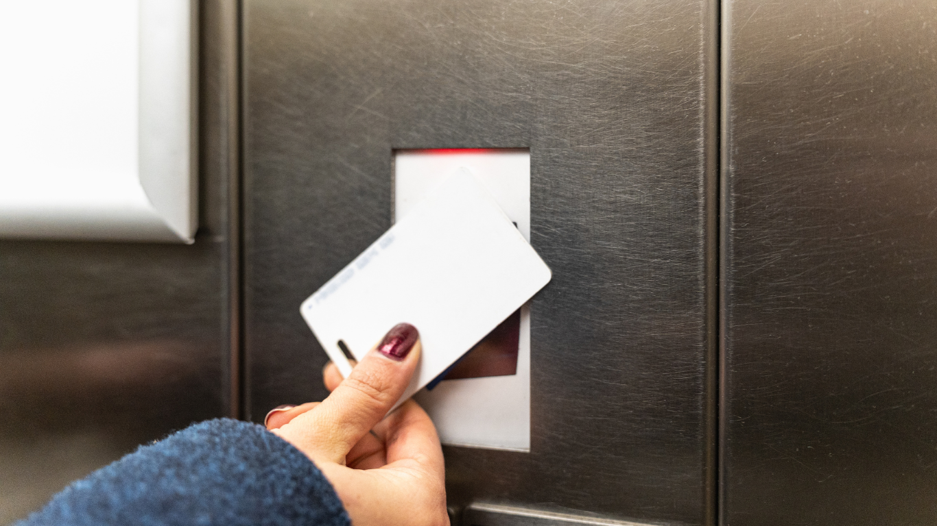 A row of stainless steel turnstiles in a building.