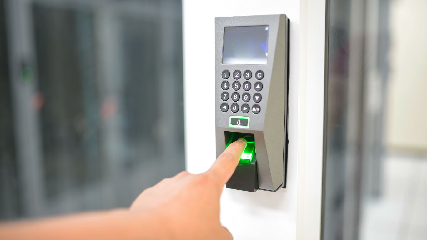 A person is pressing a button on a fingerprint scanner.