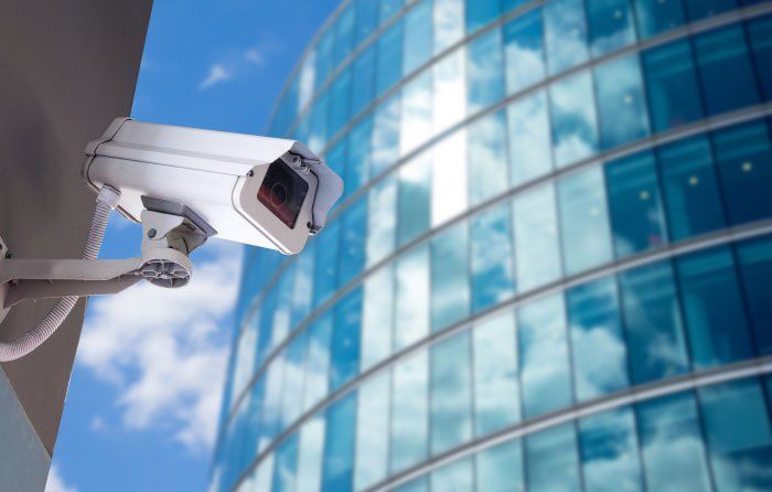 A security camera is mounted on the side of a building.