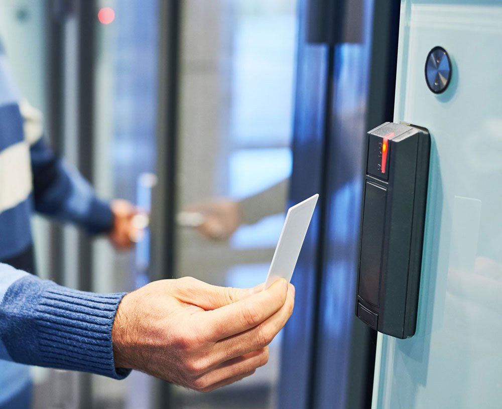A person is holding a card in front of a door.