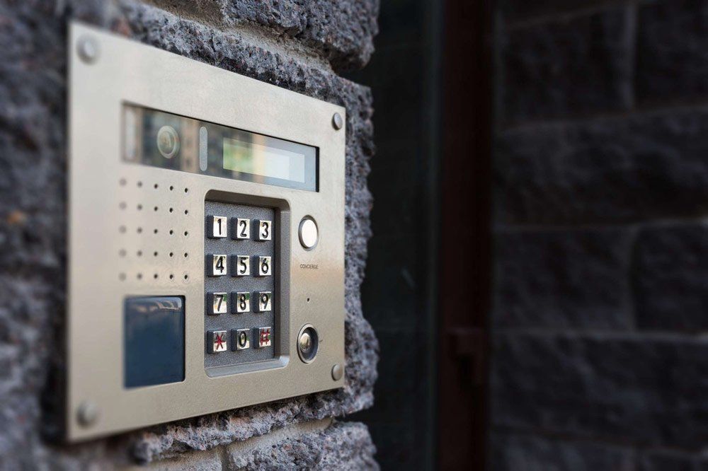 A close up of a keypad on a brick wall.