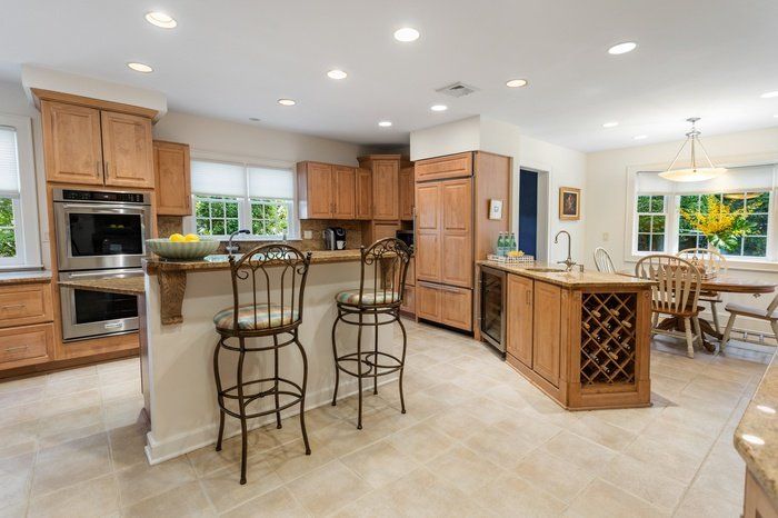 A kitchen with wooden cabinets , stainless steel appliances and a wine rack.