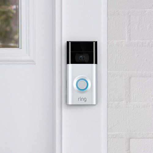 A ring doorbell is mounted on a white door.