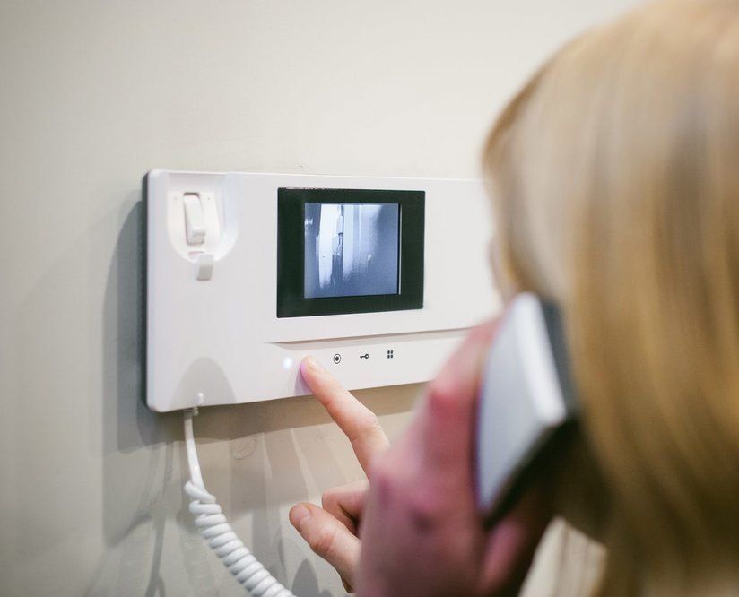 A woman is talking on a video intercom.