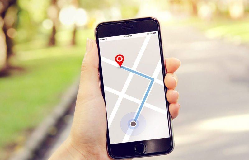 A person is holding a cell phone with a map on it.