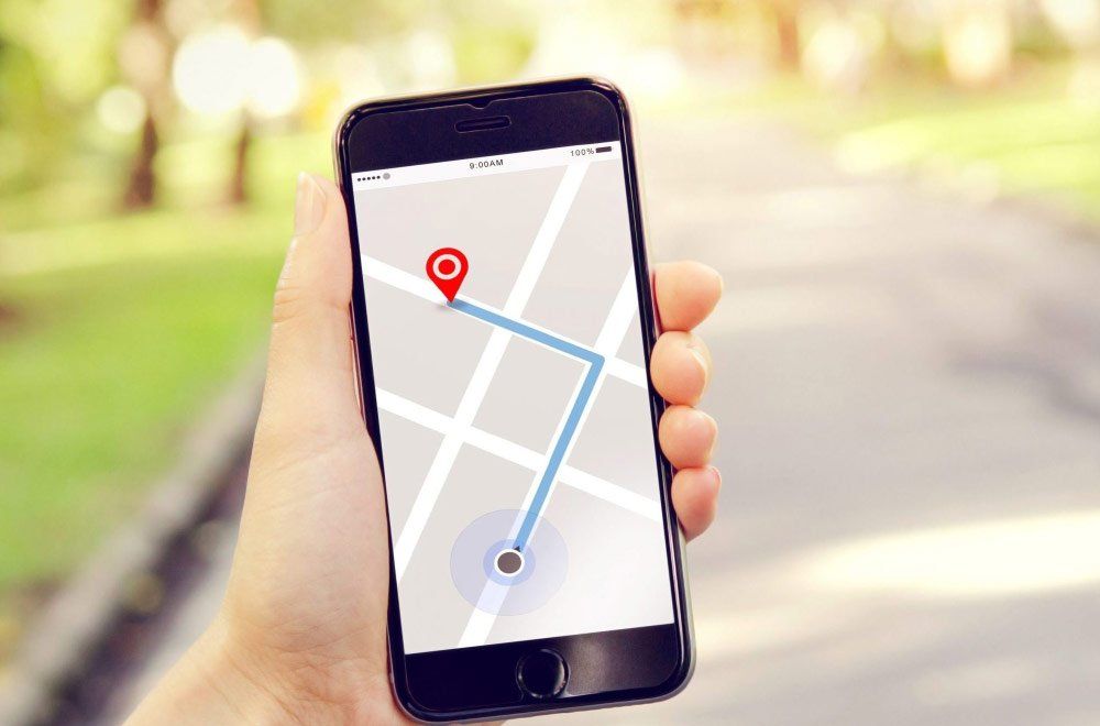 A person is holding a cell phone with a map on the screen.