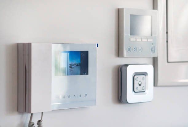 There is a video doorbell and a thermostat on the wall.