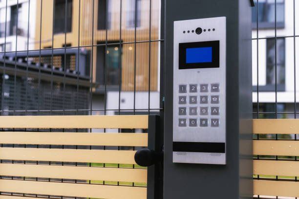 A security system is installed on a fence in front of a building.