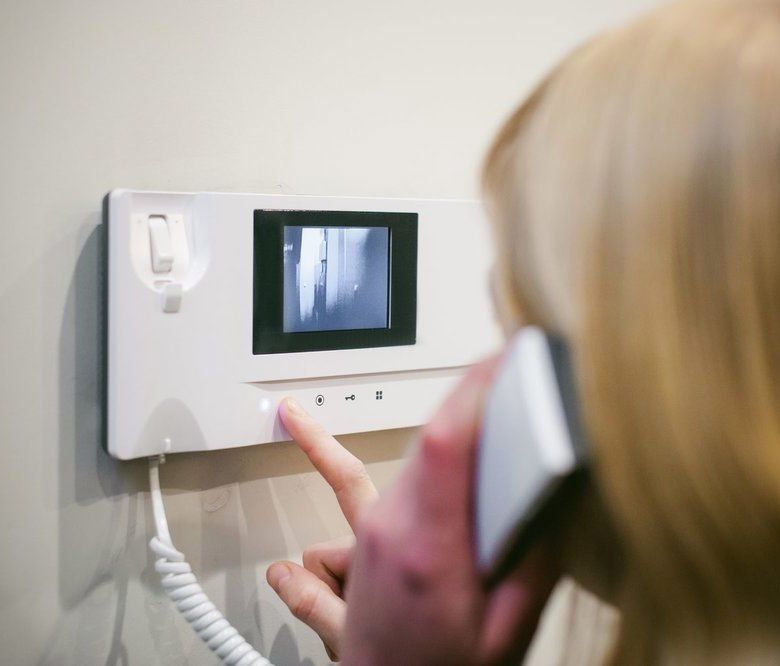 A woman is talking on a video intercom.