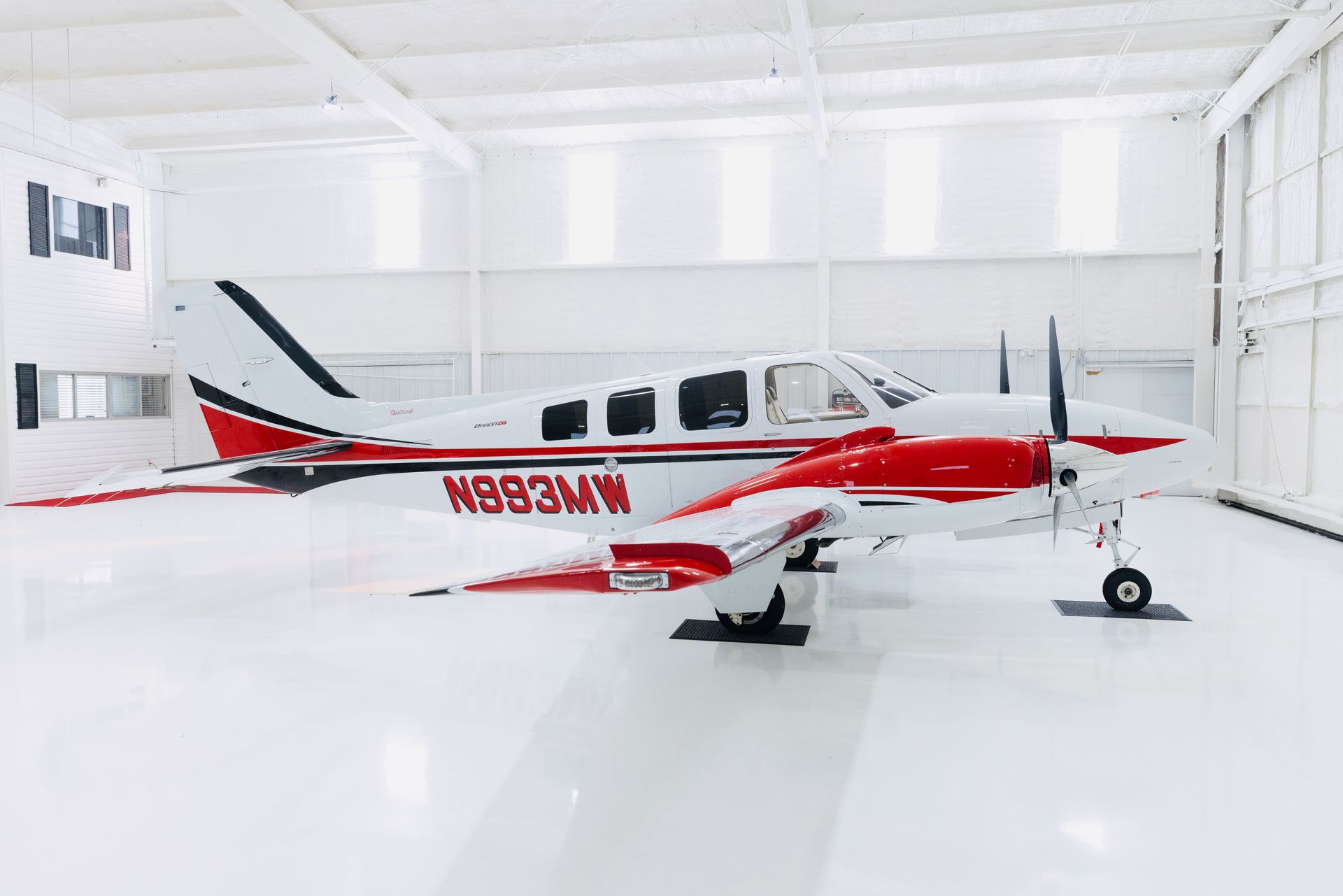2020 Beechcraft G58 Baron Aircraft finished in White with Red and Black Accent Strips.