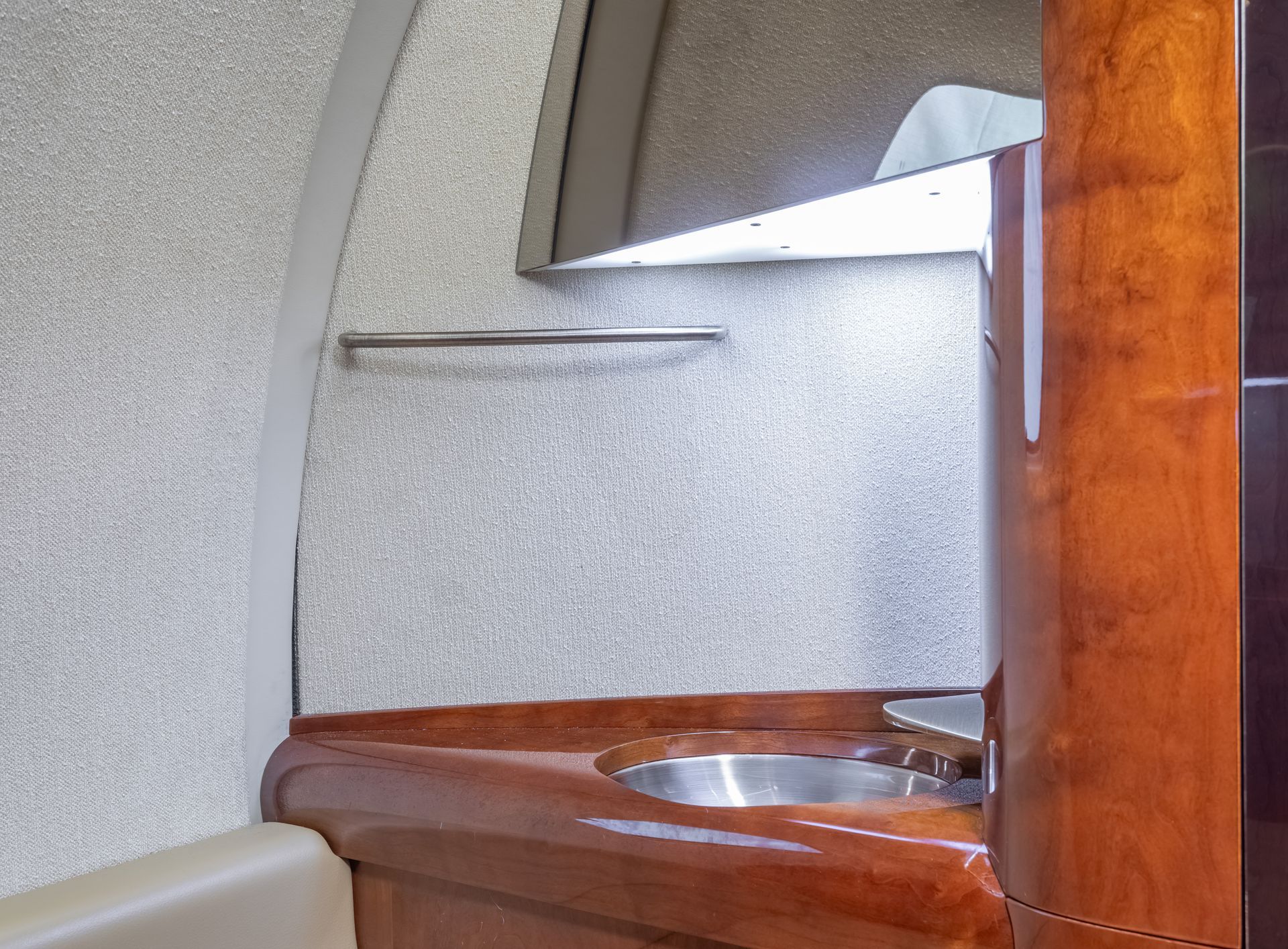 Interior with sink and wooden cabinetry. Gray wall and towel bar are visible.