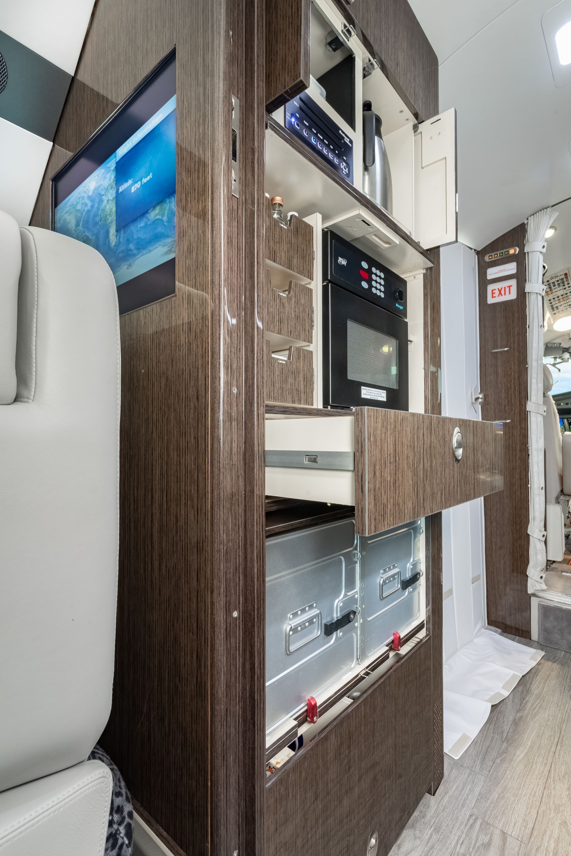 Wooden cabinet with built-in appliances and TV in a plane.