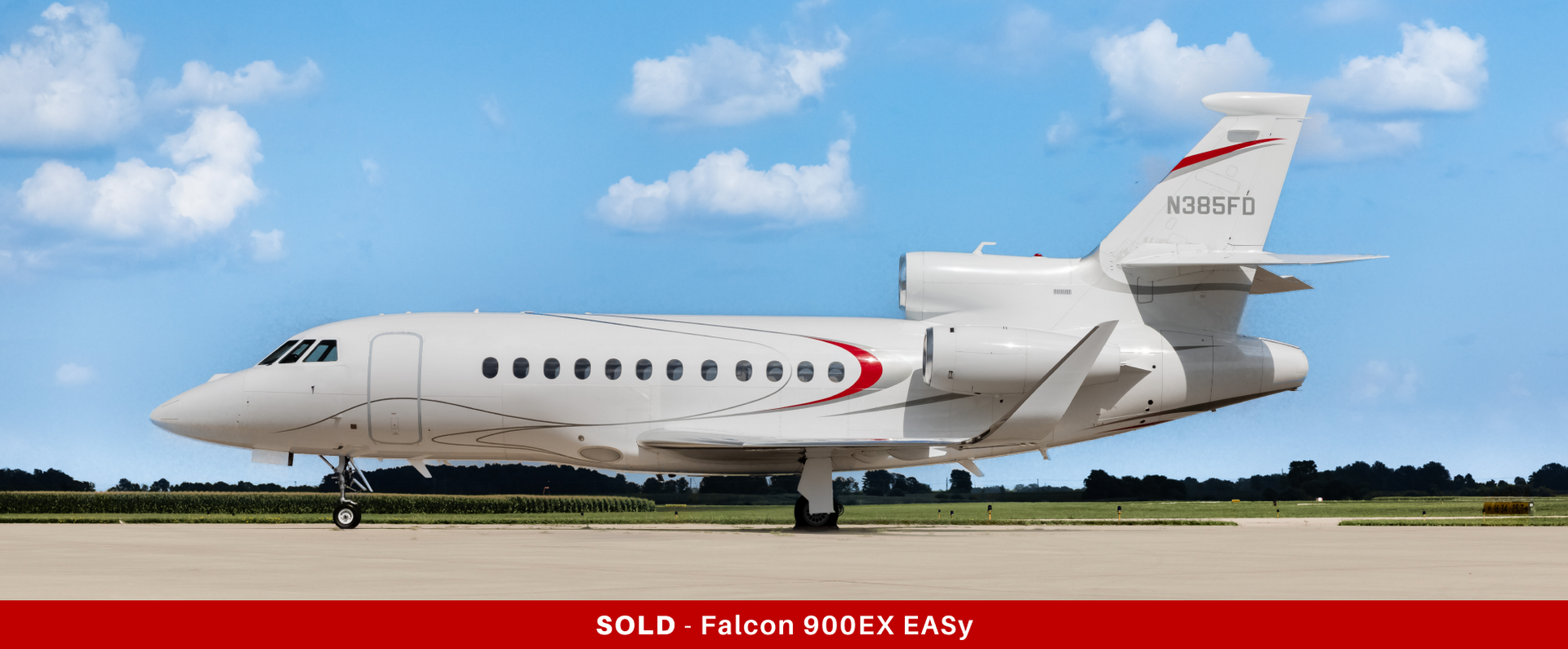 White Dassault Falcon 900LX private jet on the tarmac against a blue sky.