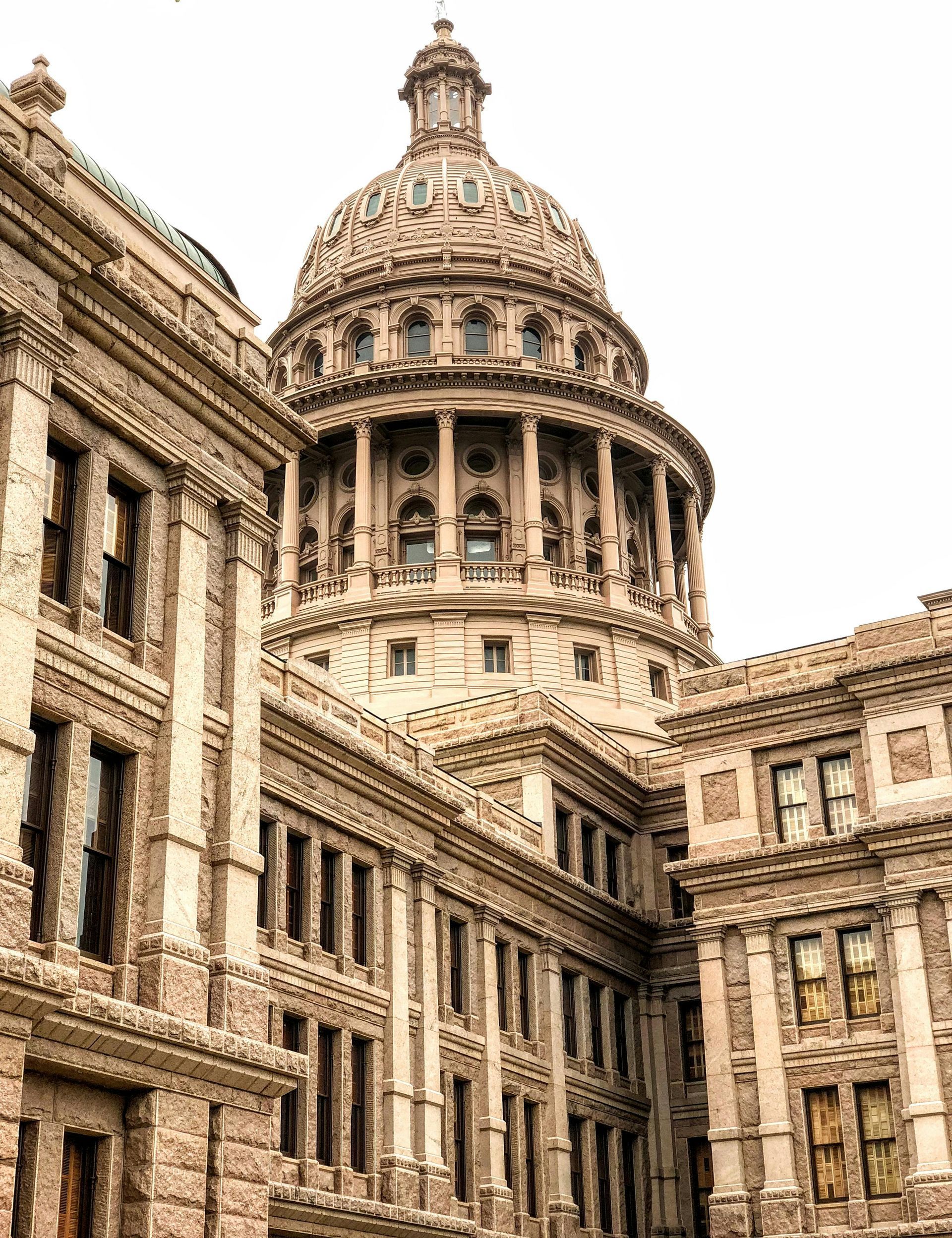 Texas State Capitol building with its large dome and surrounding stone structures.