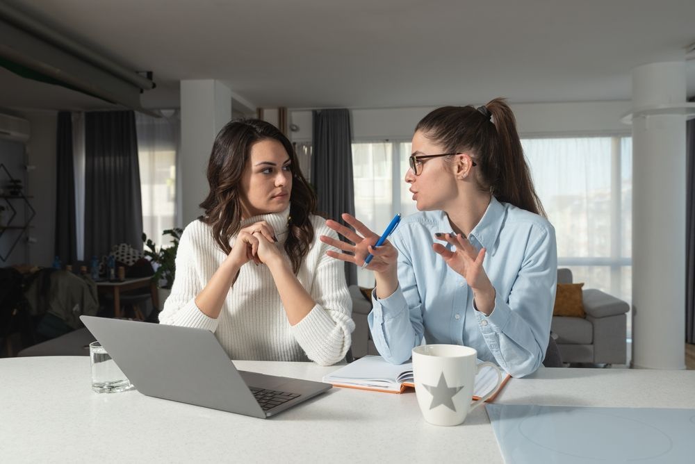 Two Female With Laptop On The Table Having A Conversation - Rehabilitation in Brisbane, QLD