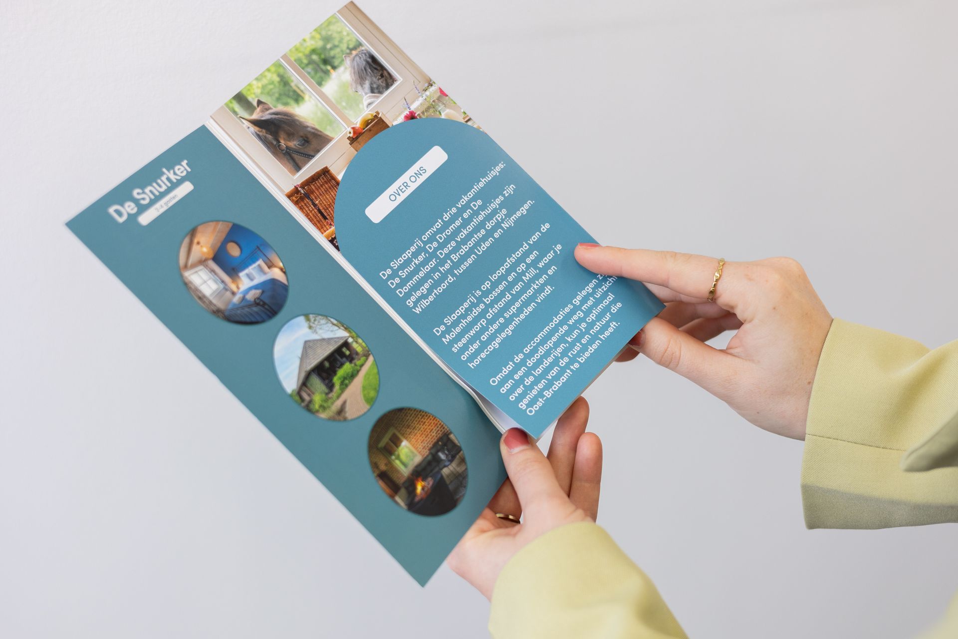 Iemand houdt een brochure in zijn handen.