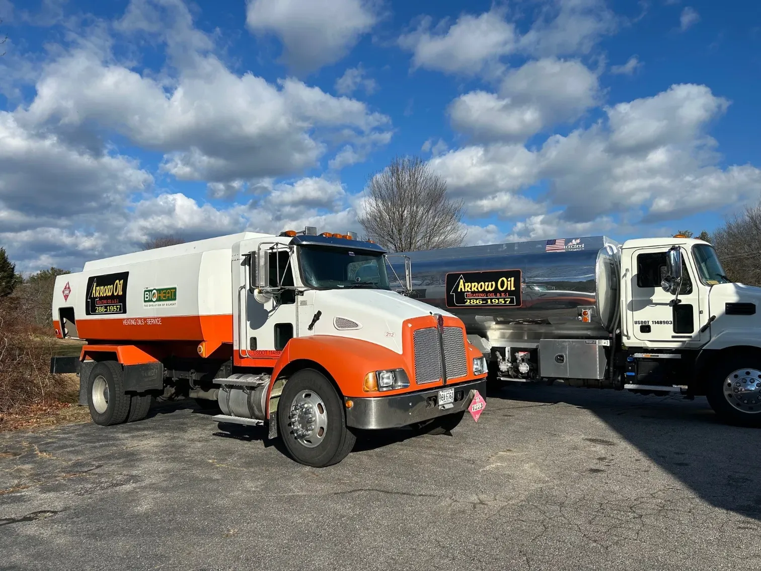 Two tanker trucks are parked next to each other on the side of the road.
