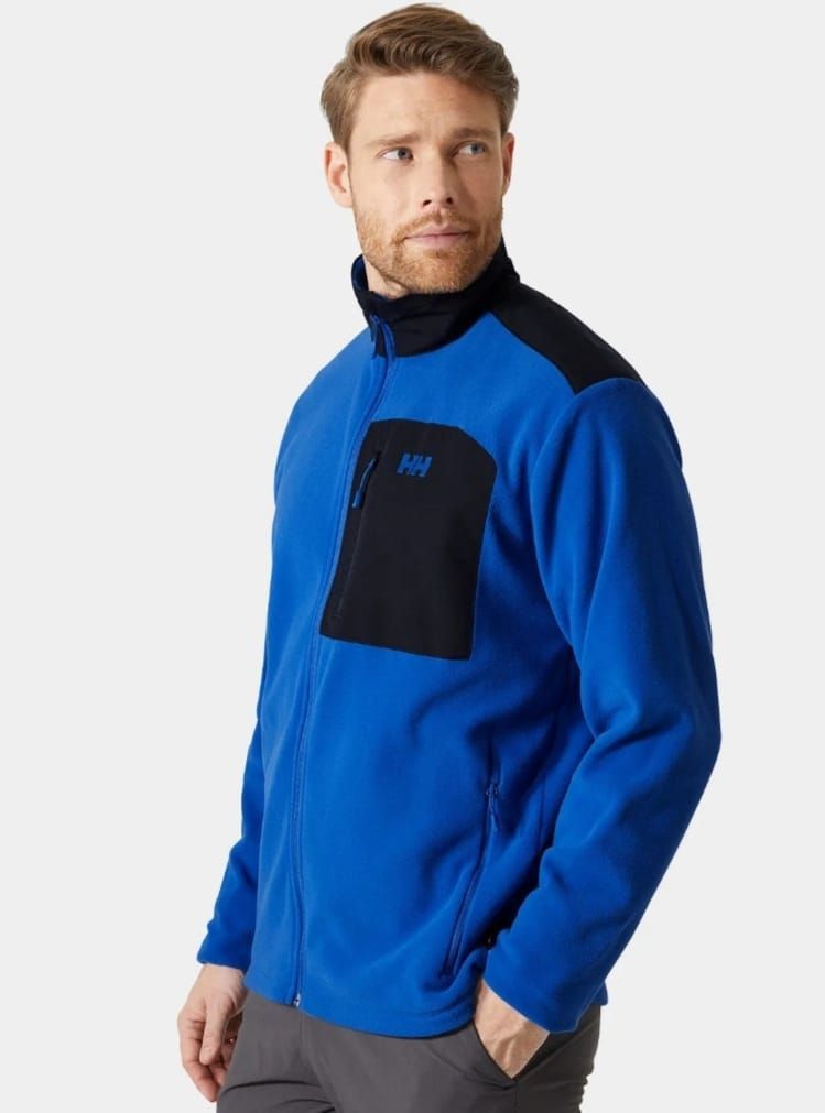 Un uomo indossa una giacca blu e nera con la lettera h sopra