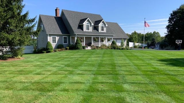 A large house with a lush green lawn in front of it.