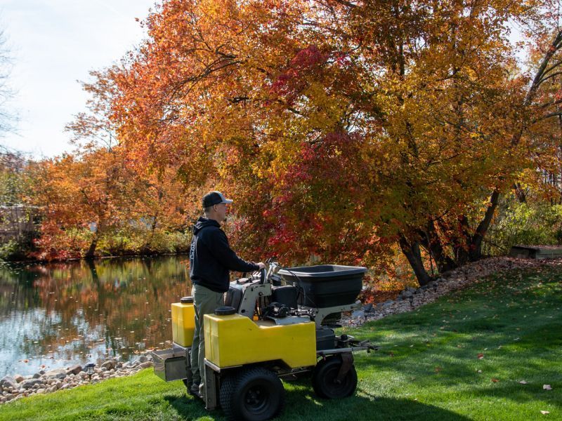 Man using fertilization tools to care for lawn.