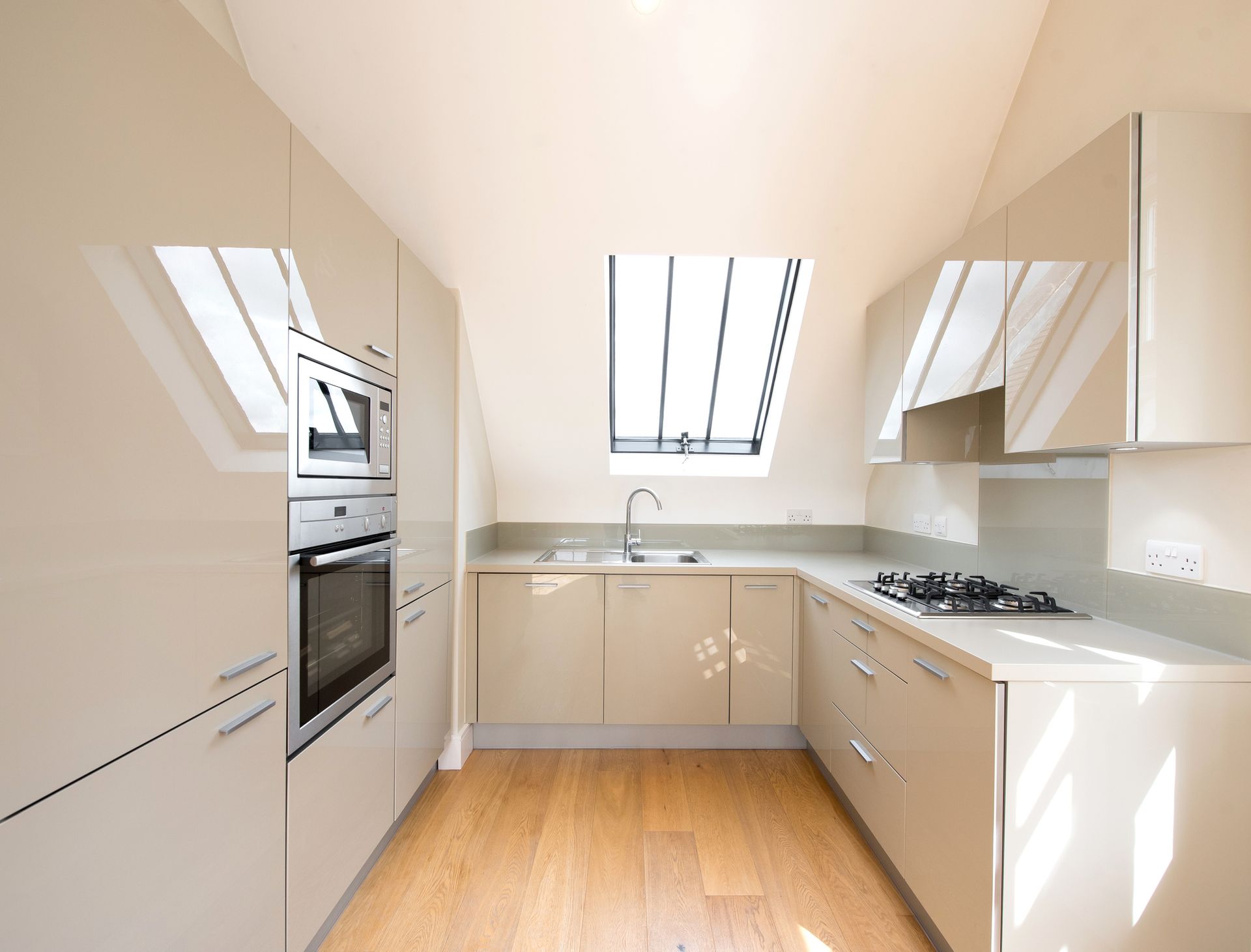 A kitchen with white cabinets and a wooden floor