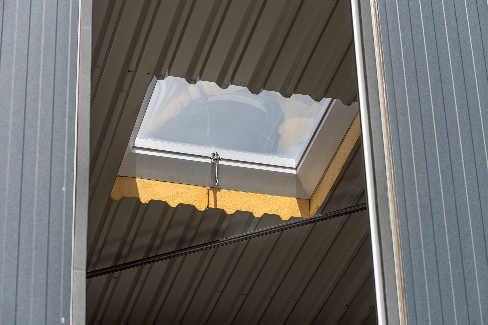 A low-angle view shows a skylight mounted on the roof of a building. A low-angle view shows a skylight mounted on the roof of a building.
