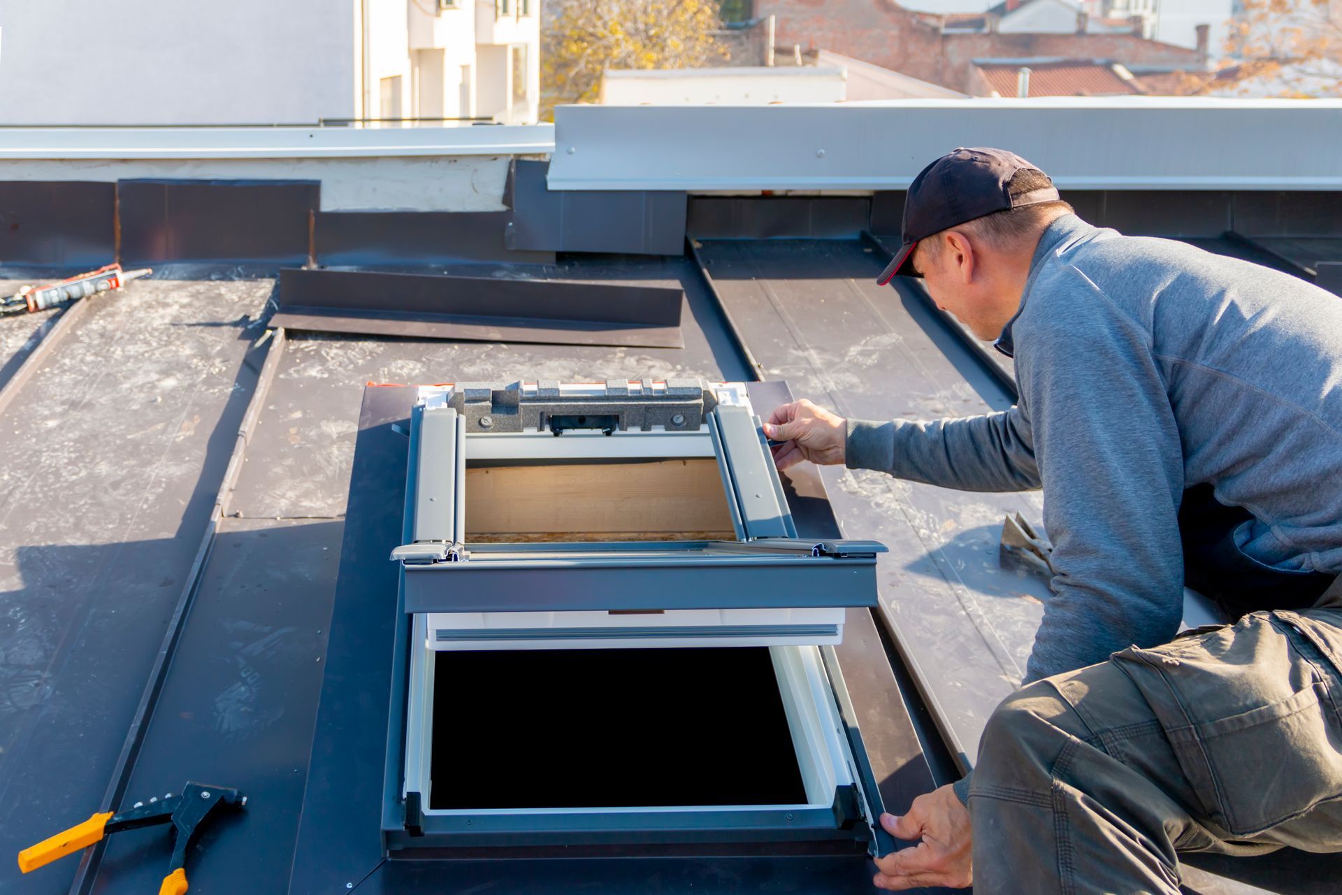 The specialist is covering the skylight with sheet metal.