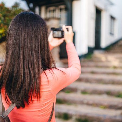 Woman photgraphing exterior of house