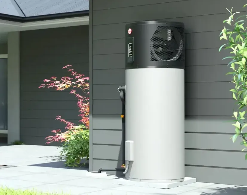 Heat pump water heater attached to a gray house exterior. — Illawater Hot Water Services in Sutherland Shire, NSW