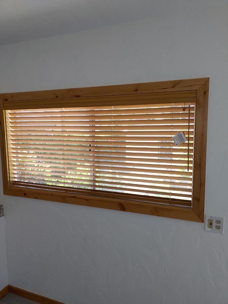 A large window with wooden blinds in a room