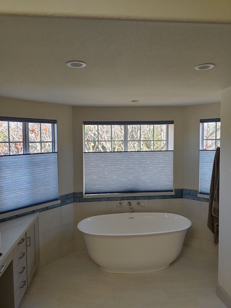 A bathroom with a tub and lots of windows