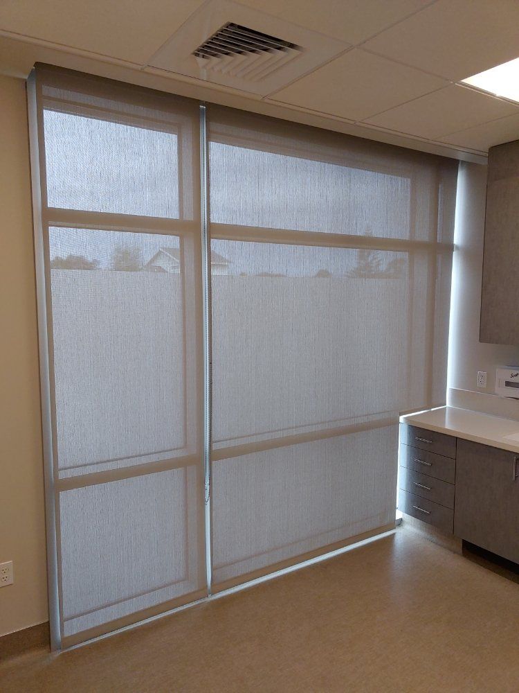 A room with a lot of windows and blinds on them.