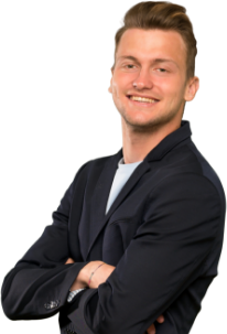 A man in a suit is standing with his arms crossed and smiling.