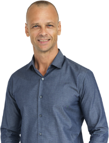 A man in a blue shirt is smiling for the camera