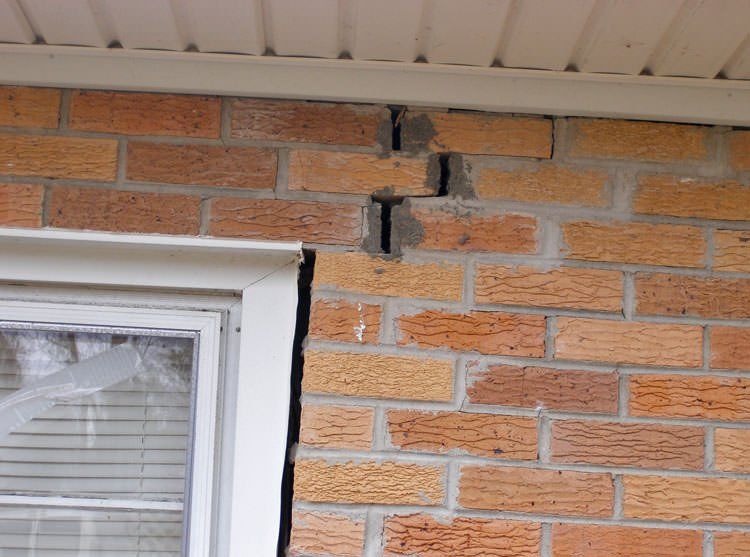 a cracked brick wall as a result of a foundation that needs repairs