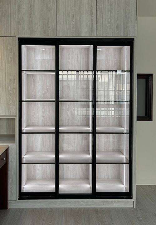 A shelf with a glass door and a lot of shelves in a room.