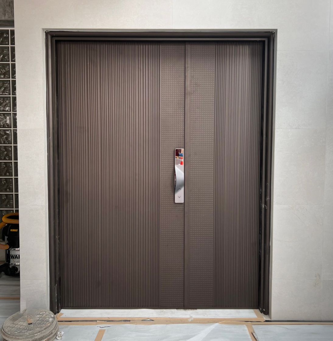 建築物上有一扇不銹鋼把手的棕色門