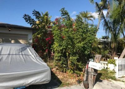 A car with a cover on it is parked in front of a house