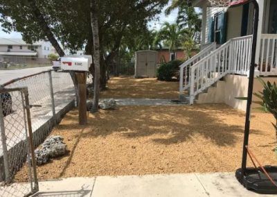 A mailbox is sitting in front of a house next to a chain link fence.