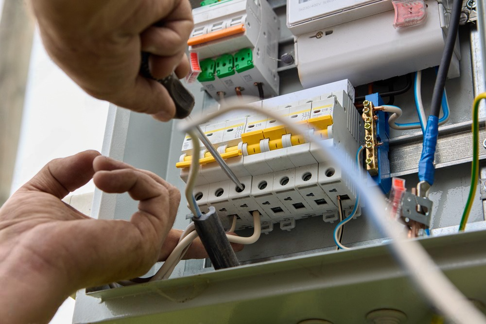 a person is working on an electrical box with a screwdriver