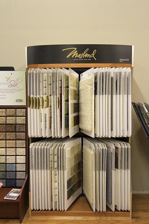 A display case filled with a variety of carpets and rugs