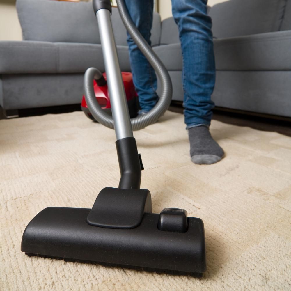 Person is Using a Vacuum Cleaner to Clean a Carpet — Boyne Carpet Cleaning in Iveragh, QLD