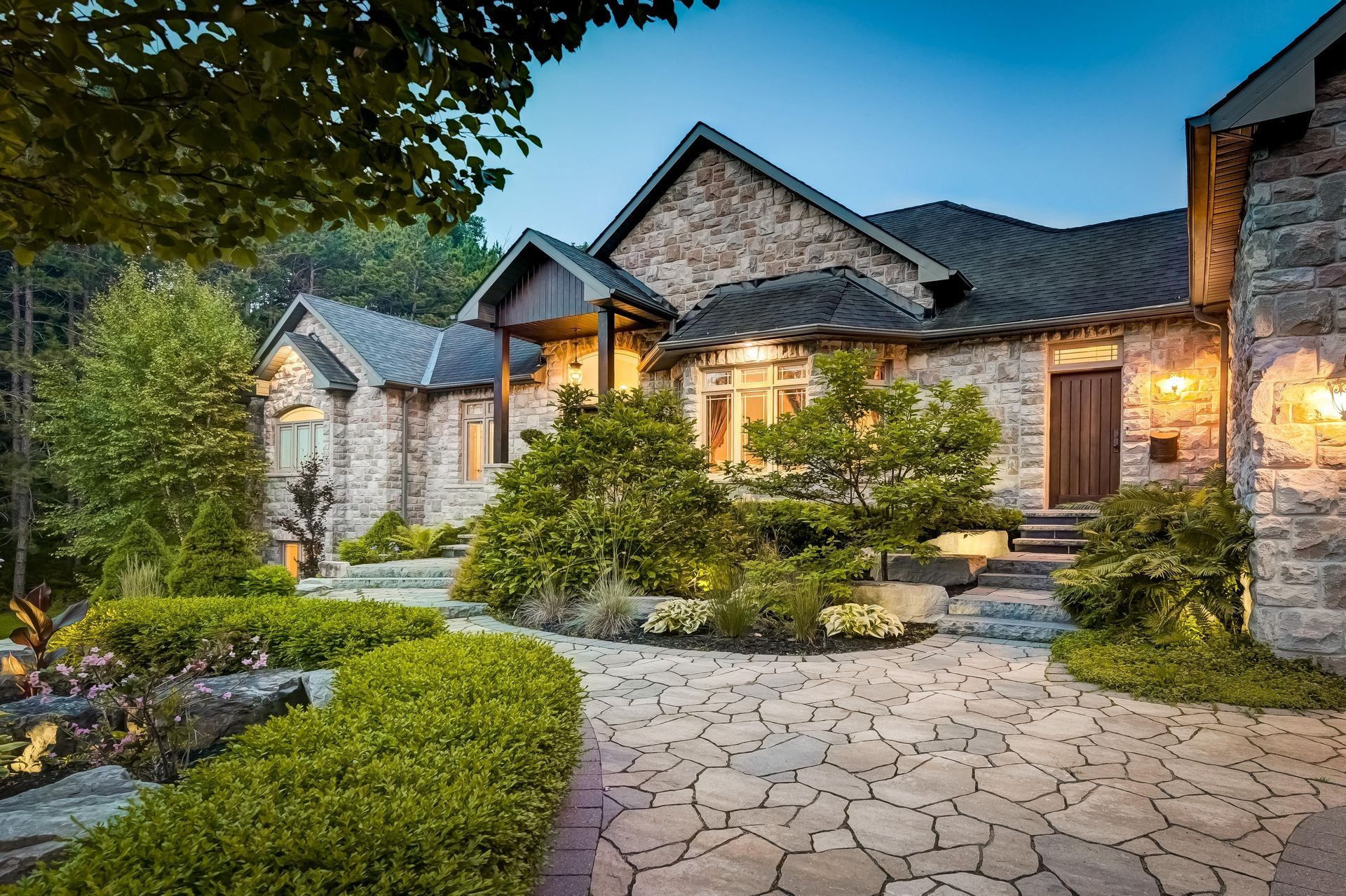 Stone house with landscaped yard and stone walkway.