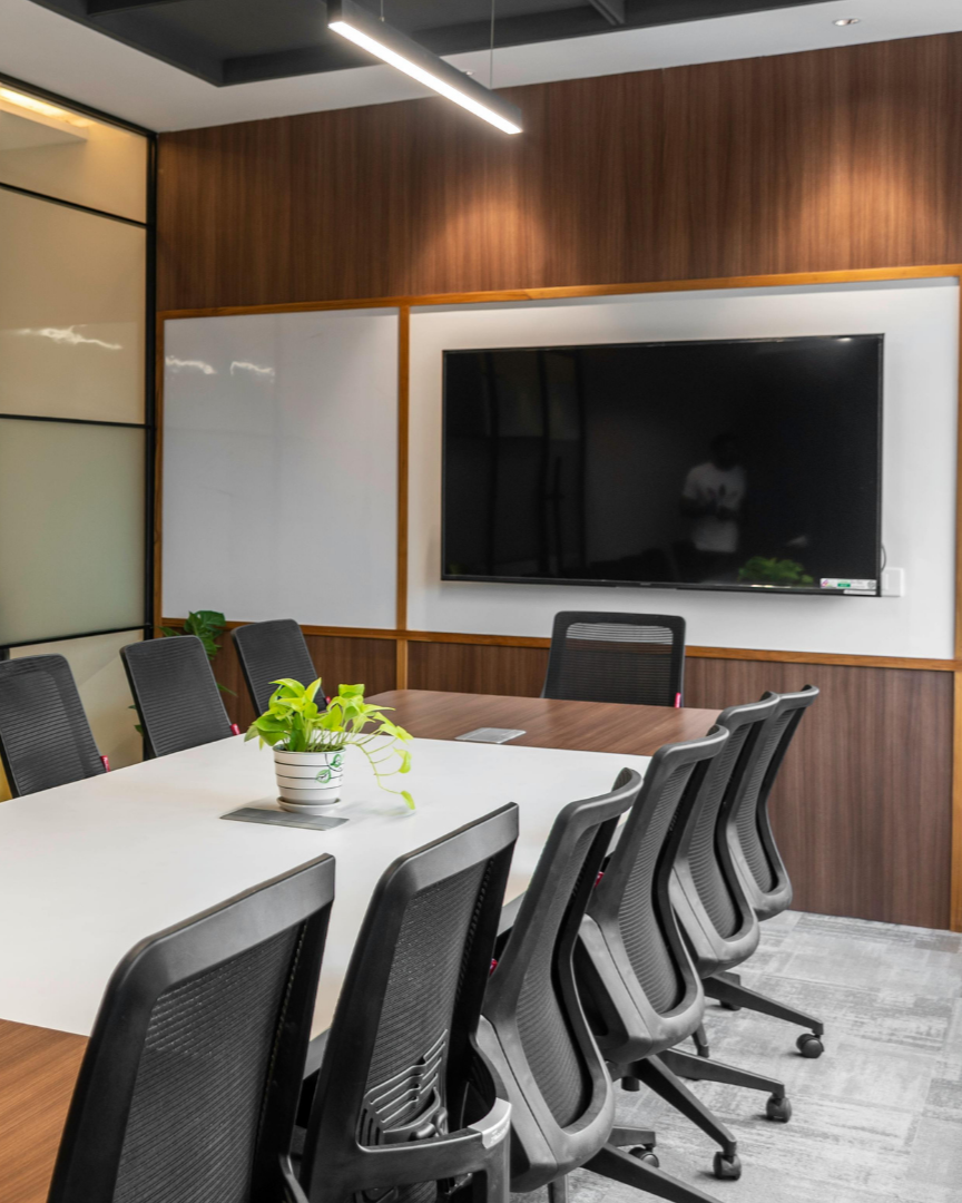 Hands of businesspeople reviewing documents and pointing at charts around a laptop in a meeting room