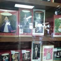 A display shelf holds several boxed Hallmark Barbie ornaments, featuring dolls in various outfits and themes.