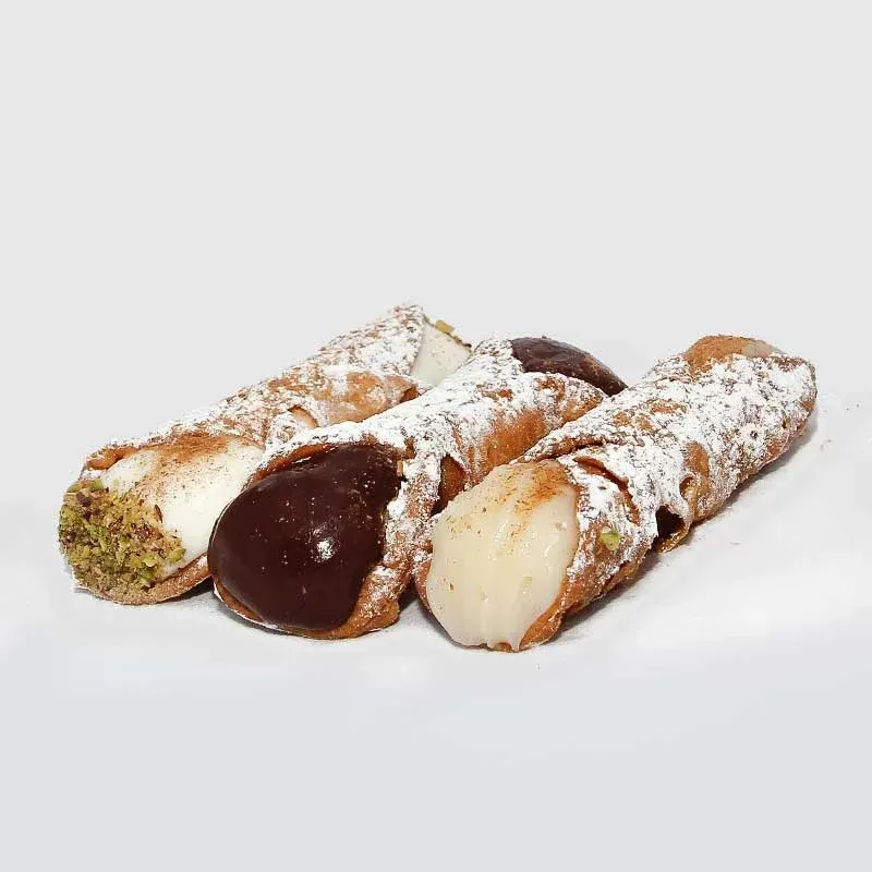 Un gruppo di cannoli con guarnizioni diverse su una superficie bianca.