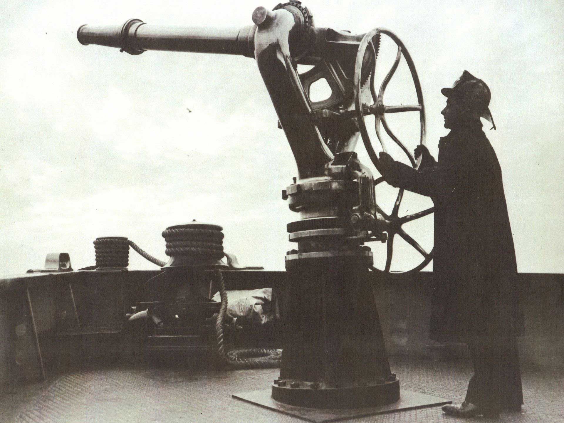A person operating a large telescope on a ship deck. A person operating a large telescope on a ship deck.