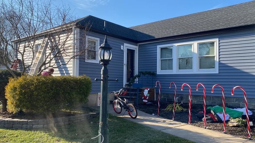 A house decorated for christmas with candy canes in front of it.