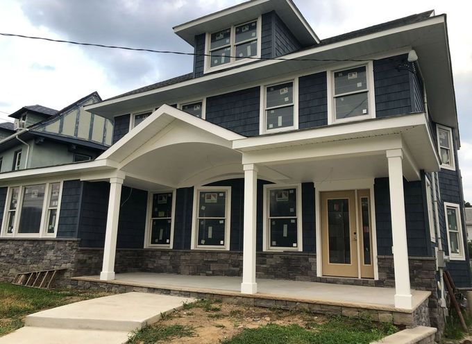 A large blue house with a white porch and stairs